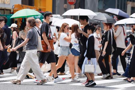 　厳しい暑さの中、東京・銀座を行き交う人たち＝６日午後
