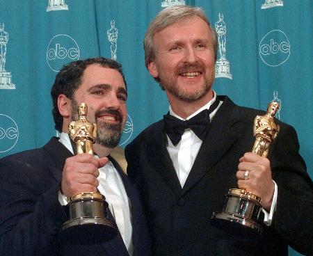 　１９９８年３月のアカデミー賞授賞式、「タイタニック」で獲得した作品賞のオスカー像を手にジェームズ・キャメロン監督（右）と笑顔のジョン・ランドー氏＝ロサンゼルス（ＡＰ＝共同）