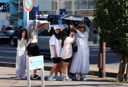 　気温４０・０度を記録した静岡市駿河区で、日陰に集まり信号待ちをする人たち＝７日午後
