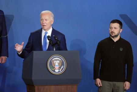 　演説するバイデン米大統領。右はウクライナのゼレンスキー大統領＝１１日、ワシントン（共同）