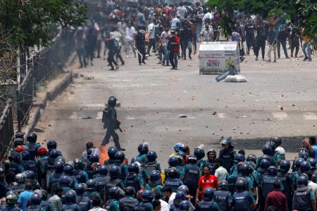 　１８日、バングラデシュの首都ダッカで、警察官らと衝突するデモ参加者ら（ロイター＝共同）