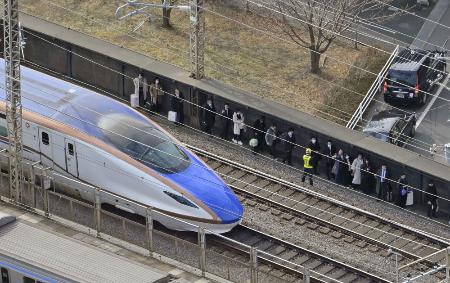 　１月、さいたま市中央区で停車した新幹線から降り、線路脇を歩く人たち