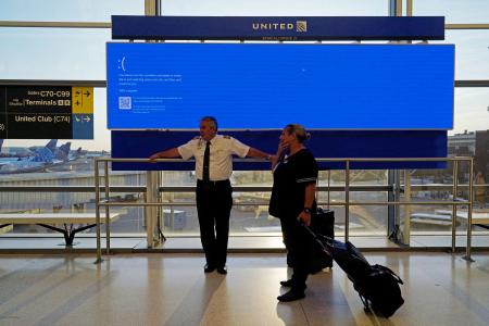 　システム障害で青一色となった空港のスクリーン＝１９日、米ニュージャージー州（ロイター＝共同）