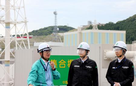 　中国電力の担当者（左）から島根原発の施設について説明を受ける原子力規制委の山中伸介委員長（中央）ら＝２０日午前、松江市