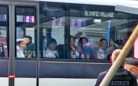 　２１日、パリの空港に到着し、バスから手を振る北朝鮮の代表選手団（共同）