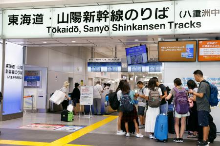 　東海道新幹線が運転見合わせとなり、ＪＲ東京駅の改札前で待つ人たち＝２２日午前