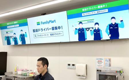 　ファミリーマート店舗のデジタルサイネージに表示された配送員募集の案内＝２日、東京都中央区