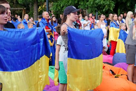 　ウクライナ・キーウのパブリックビューイング会場で、ウクライナの国旗を掲げる観客＝２６日（共同）