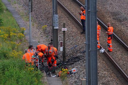 　２６日、高速列車網への破壊行為があった現場で作業するフランス国鉄の職員ら＝フランス北部（ロイター＝共同）