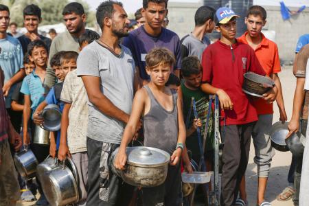 　ガザ中部デールバラハで、慈善団体からの食料を受け取るため列に並ぶパレスチナ人ら＝２６日（ゲッティ＝共同）