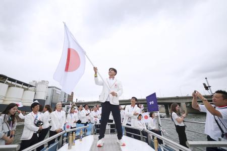 　セーヌ川で行われたパリ五輪の開会式で、日の丸を手にする日本選手団旗手の半井重幸（中央）＝２６日、パリ（ゲッティ＝共同）