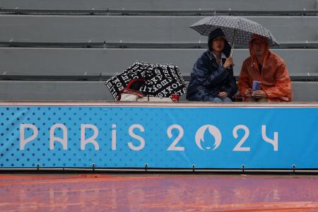 　雨が降る中、試合開始を待つ観客＝２７日、パリ（ロイター＝共同）