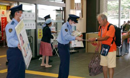 　２０１８年に行方不明になったフランス人女性の情報提供を呼びかける栃木県警の警察官ら＝２９日午前、栃木県日光市