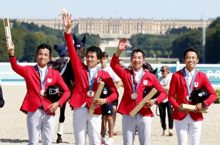 　パリ五輪馬術の総合馬術団体で銅メダルを獲得し、観客の声援に応える（左から）北島隆三、大岩義明、田中利幸、戸本一真＝２９日、パリ郊外（共同）