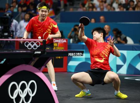 　卓球の混合ダブルス決勝でプレーする中国の王楚欽（左）、孫穎莎組＝３０日、パリ（ロイター＝共同）