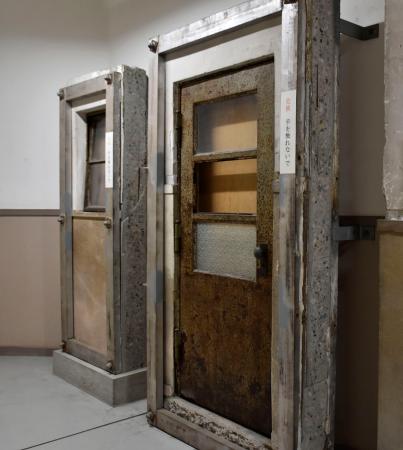 　袋町小の平和資料館に展示されている、被爆で壊れた扉（手前）と窓＝広島市