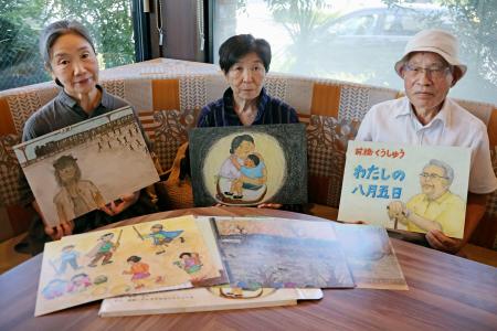 　前橋空襲を伝える紙芝居「わたしの八月五日」を手にする制作者ら。（左から）企画した鈴木みどりさん、絵を担当した宮田栄子さん、市民団体事務局長の浅尾剛さん＝２日、前橋市