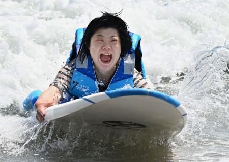 　障害者向けの体験会でサーフィンを楽しむ山崎美佳さん＝４日午前、福島県いわき市の勿来海水浴場