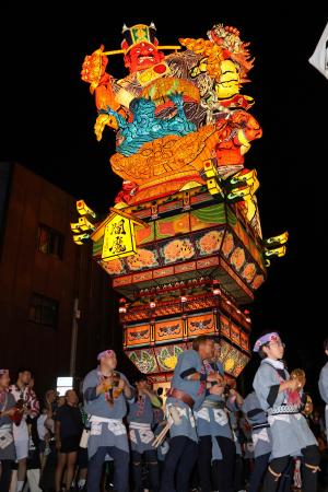 　市街地を練り歩く、閻魔大王が裁きを下す姿を表現した山車＝４日夜、青森県五所川原市