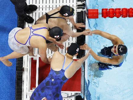 　競泳女子４００メートルメドレーリレー決勝のレースを終え、メンバーに迎えられる池江璃花子（右）＝４日、パリ郊外（共同）
