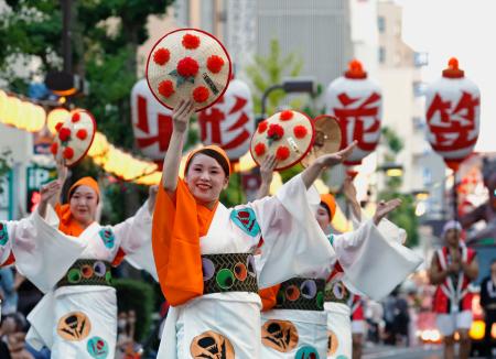 　「山形花笠まつり」で紅花をあしらった花笠を手に舞を披露する踊り手＝５日夕、山形市