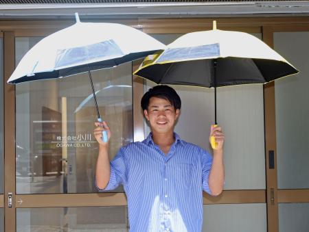 　レイングッズ製造会社「小川」が販売する子ども向け晴雨兼用の傘を持つ、広報担当の小川太志さん＝７月、名古屋市