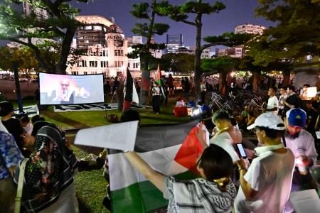 　イスラエルが平和記念式典に招待されたことに抗議する市民集会。後方は原爆ドーム＝６日夜、広島市の平和記念公園