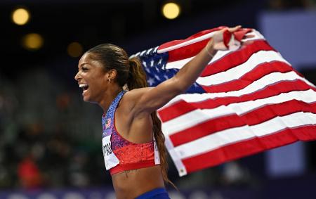 　陸上女子２００ｍを制し、星条旗を手に喜ぶガブリエル・トーマス＝６日、パリ郊外（ロイター＝共同）