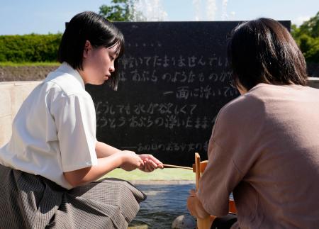 　平和公園の「平和の泉」から献水用の水をくむ生徒ら＝８日午前、長崎市