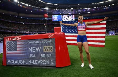 　陸上女子４００ｍ障害を世界新で制し、電光掲示板の横でポーズをとるシドニー・マクラフリンレブロニ＝８日、パリ郊外（ロイター＝共同）