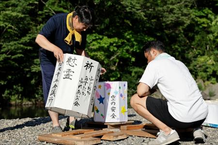 　日航ジャンボ機墜落事故から３９年となるのを前に、神流川の河原で灯籠を準備する人たち＝１１日午後、群馬県上野村