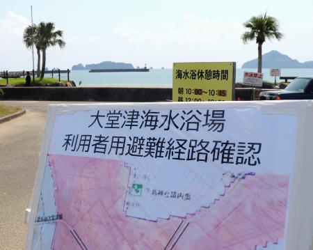 　津波からの避難経路を示す看板が設置された、宮崎県日南市の大堂津海水浴場＝１４日午前