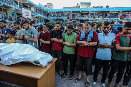 　イスラエル軍の攻撃で死亡したＵＮＲＷＡ職員らの葬儀で祈る人々＝１１日、ガザ中部ヌセイラト（ゲッティ＝共同）