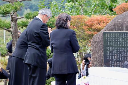 　御嶽山の噴火から１０年となり、慰霊碑を前に手を合わせる遺族ら＝２７日午前、長野県王滝村