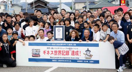 　石川県志賀町で行われたギネス記録挑戦イベントで、記録を達成し笑顔で記念撮影する参加者ら＝５日午後