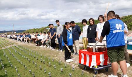 　石川県志賀町で行われたギネス記録挑戦イベントで、ベンチに腰かけて和太鼓をたたく順番を待つ参加者＝５日午前