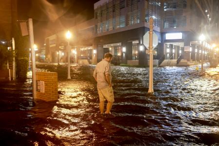 　ハリケーン「ミルトン」の影響で冠水した道を歩く男性＝９日、米南部フロリダ州（ゲッティ＝共同）