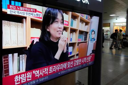 　ノーベル文学賞に決まった韓国の作家ハン・ガンさんのニュースを伝えるテレビ映像＝１０日、ソウル駅（ＡＰ＝共同）