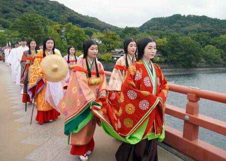 　平安装束をまとい越前への旅を再現した行列。先頭が紫式部役の女性＝１８日午前、京都府宇治市