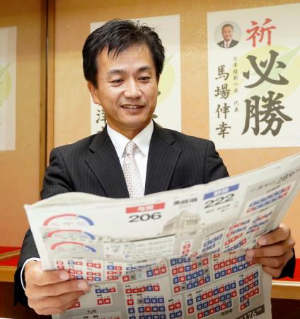 　衆院福岡１１区で初当選し、新聞に目を通す日本維新の会の村上智信氏＝２８日午前、福岡県行橋市