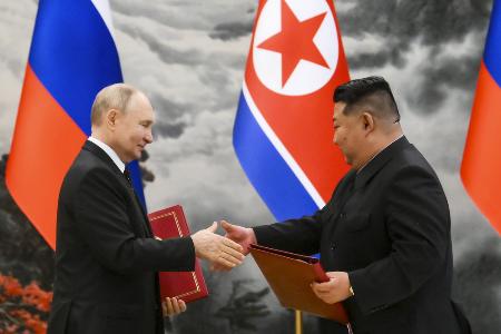 　式典で文書を交換するロシアのプーチン大統領（左）と北朝鮮の金正恩朝鮮労働党総書記＝６月、平壌（ＡＰ＝共同）