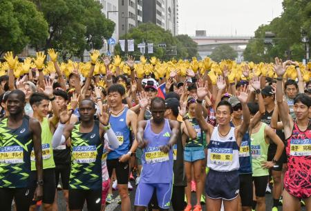 　神戸マラソンで、復興の象徴のヒマワリを表す黄色の手袋を着けたランナーたち＝１７日午前、神戸市