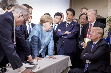 　２０１８年６月、カナダでのＧ７サミットでトランプ米大統領（右端）に向かい身を乗り出すドイツのメルケル首相（中央左）（ドイツ政府提供、ＡＰ＝共同）