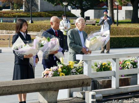 　ノーベル平和賞授賞式を終え、広島市の原爆慰霊碑を訪れた（左から）甲斐なつきさん、箕牧智之さん、田中聡司さん＝１８日午前