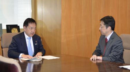 　浅尾環境相（左）と面会し、熊本県水俣市への訪問を求める木村敬知事＝２５日午前、環境省