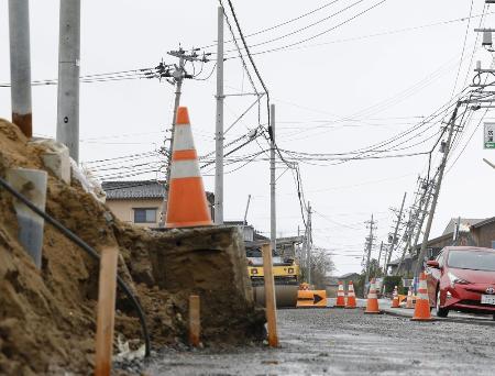 　能登半島地震による液状化被害が残る石川県内灘町西荒屋地区。道路の復旧工事が続く＝２２日