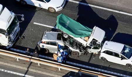 　東名高速道路上り線の東京インターチェンジ付近で発生した多重事故でつぶれた車両＝２７日午後０時３６分、東京都世田谷区（共同通信社ヘリから）