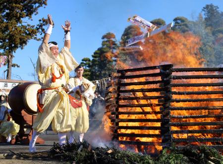 　成田山新勝寺の「納め札お焚き上げ」で、炎の中にお札を投げ入れる僧侶＝２８日午前、千葉県成田市