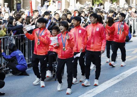 　パリ五輪・パラリンピックの日本選手団による合同パレードで行進するレスリング女子の藤波朱理（手前右）と男子の清岡幸大郎（同左）ら＝１１月、東京・日本橋