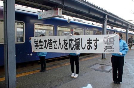 　「のと鉄道」七尾駅で受験生を応援する横断幕を掲げる職員＝７日午前、石川県七尾市